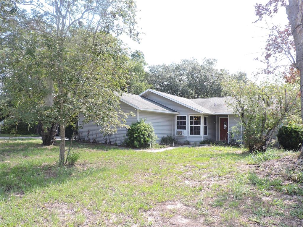A single-story house with light gray siding and a red front door sits on a lot — 5324 FAIRMONT ROAD, LAKE WALES, FL
