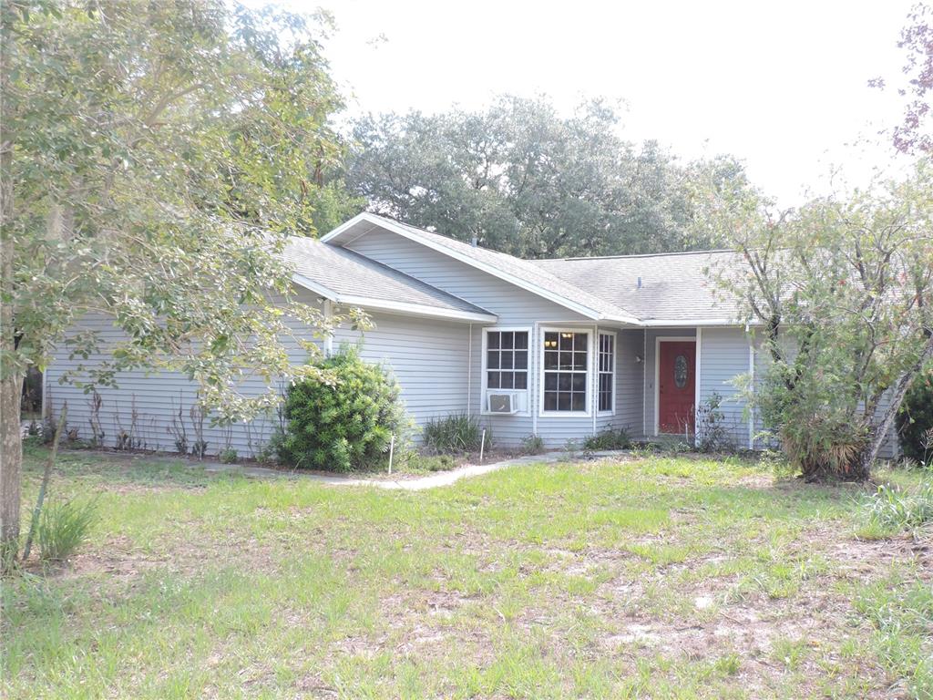 A single-story house with gray siding, a red front door, and a grassy front yard — 5324 FAIRMONT ROAD, LAKE WALES, FL