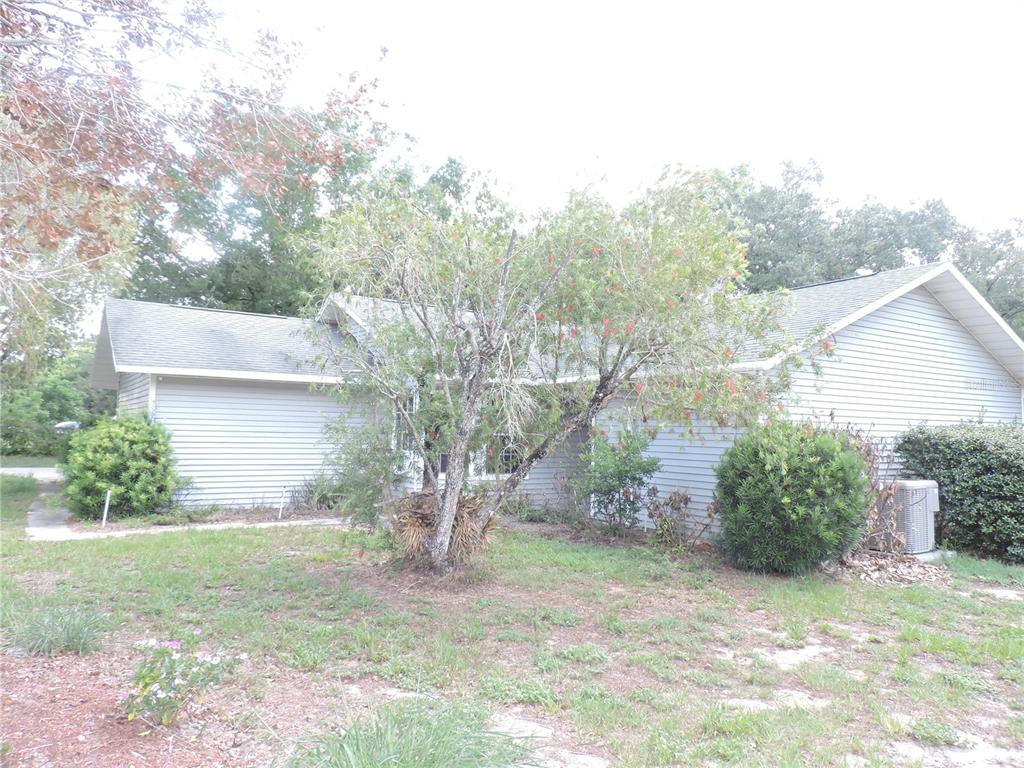 A single-story house with light gray siding and a front yard featuring a small tree — 5324 FAIRMONT ROAD, LAKE WALES, FL