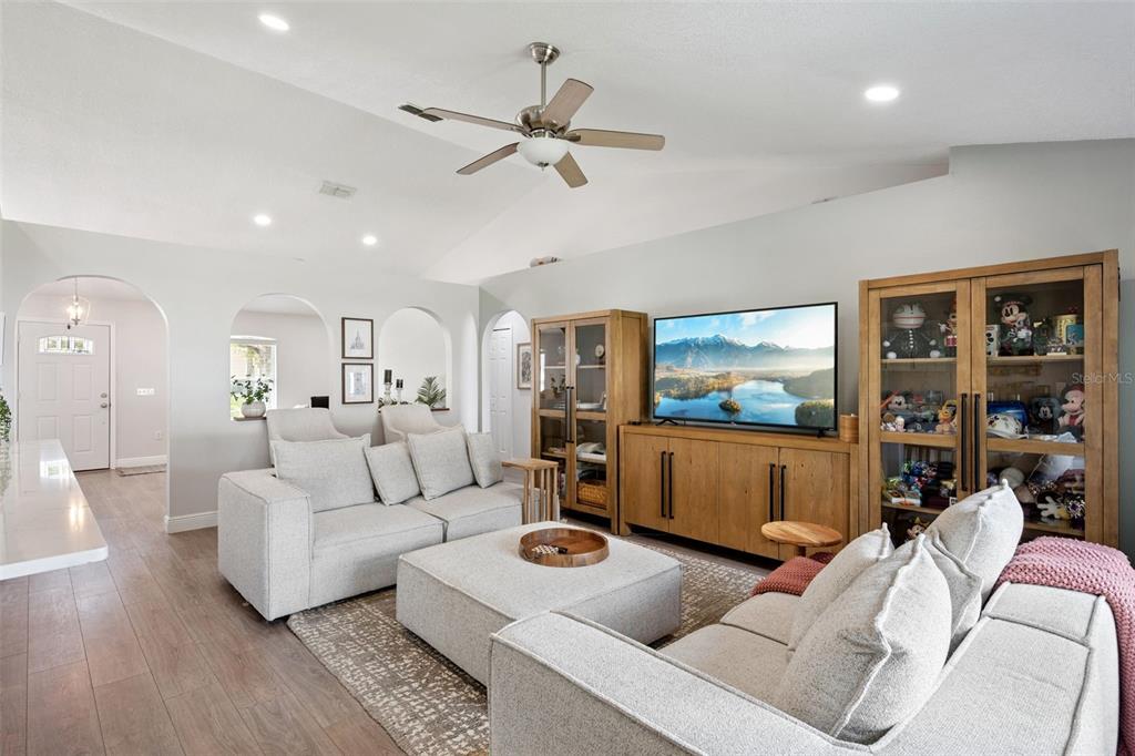 A living room features light gray walls, wood-look flooring, a sectional sofa, and built-in cabinets — 33 TIMBERCREEK PINES CIRCLE, WINTER GARDEN, FL