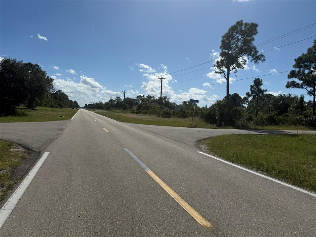 A paved road stretches into the distance at an intersection with a rural side street — 627 COLUMBUS BOULEVARD S, LEHIGH ACRES, FL