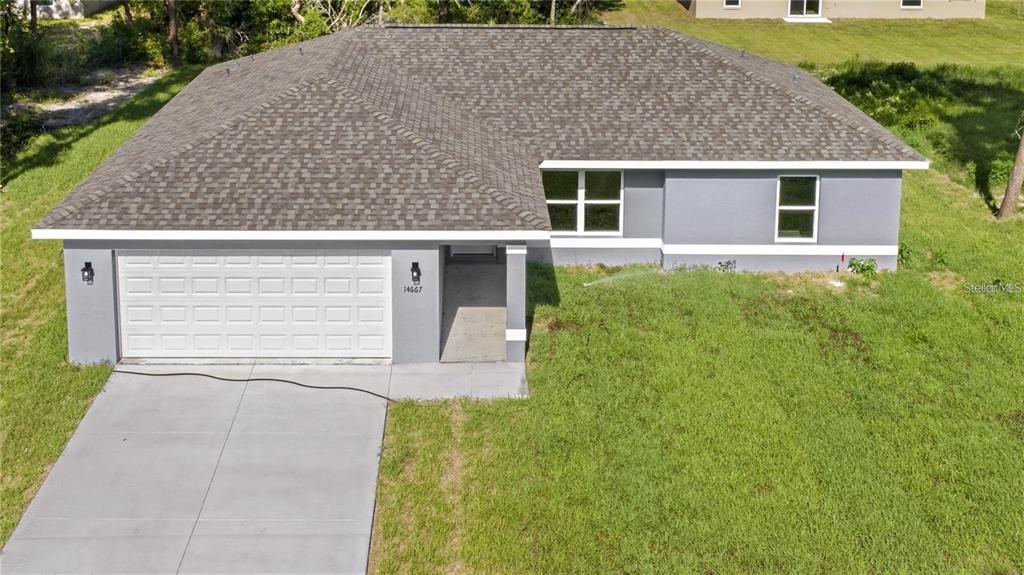 An aerial view of a single-story house with a gray exterior and a shingled roof — 13668 SW 112TH STREET, DUNNELLON, FL