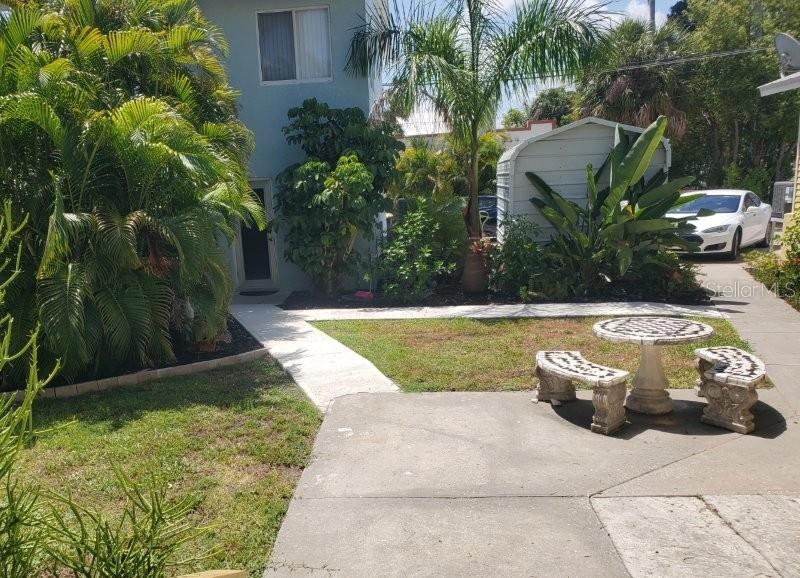 A patio with a stone table and benches sits in front of a blue building — 457 W MARION AVENUE UNIT B, PUNTA GORDA, FL
