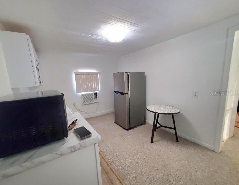 A small kitchen area features a refrigerator, a microwave, and a small round table — 457 W MARION AVENUE UNIT B, PUNTA GORDA, FL