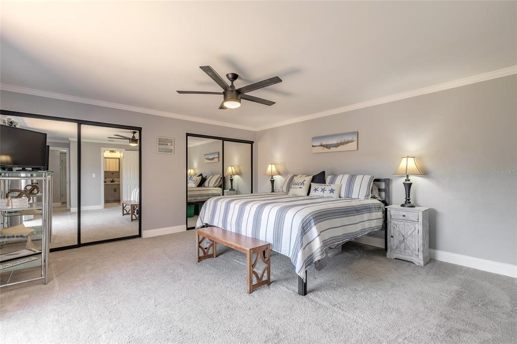 A bedroom features a bed with striped bedding, a ceiling fan, and mirrored closet doors — 178 MOONSTONE COURT, PORT ORANGE, FL