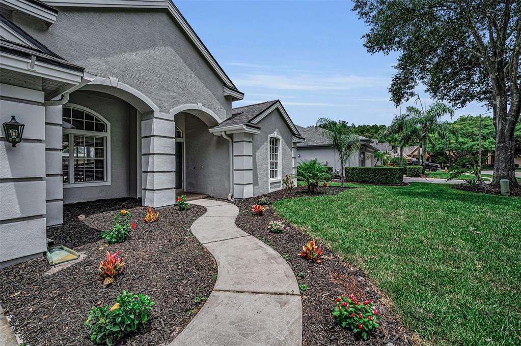 An aerial view shows a single-story house with a shingled roof, driveway, and backyard pond — 4084 LIGUSTRUM DRIVE, PALM HARBOR, FL