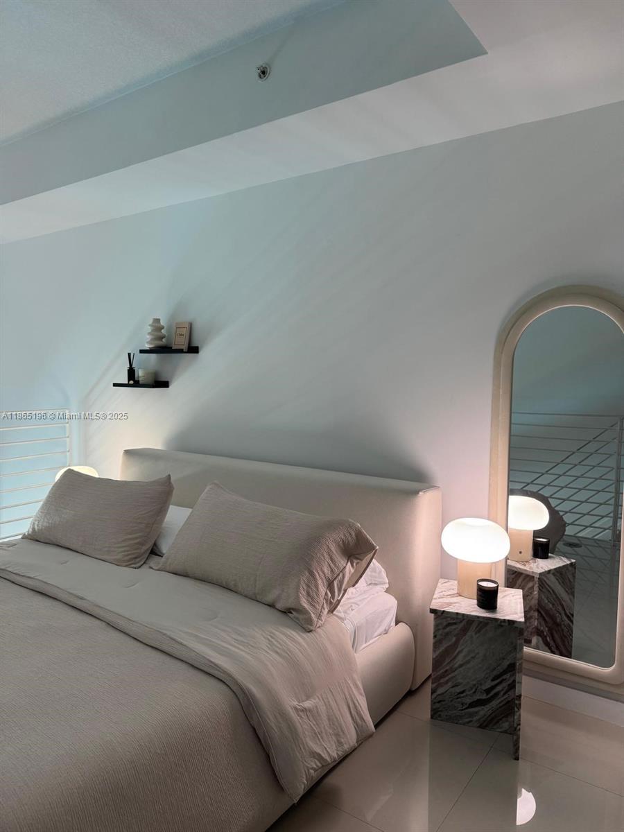 A modern bedroom features a neutral upholstered bed, marble side table, and an arched floor mirror — 60 SW 13th St # 1406, Miami FL 33130, MIAMI, FL