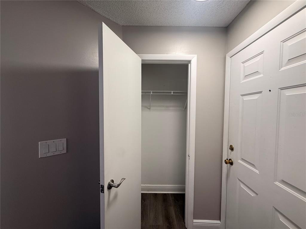 A white interior door opens to a small closet with a wire shelf and flooring — 715 SUGAR BAY WAY UNIT 103, LAKE MARY, FL