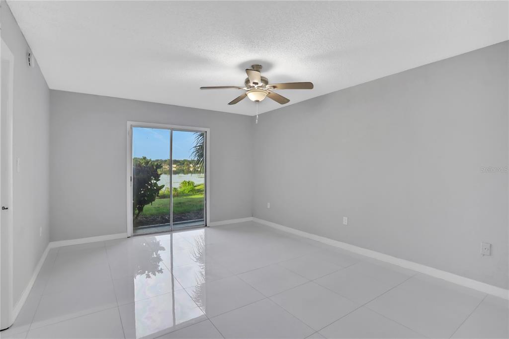 A bright room with white tile floors, a ceiling fan, and sliding glass doors — 540 ORANGE DRIVE UNIT 13, ALTAMONTE SPRINGS, FL