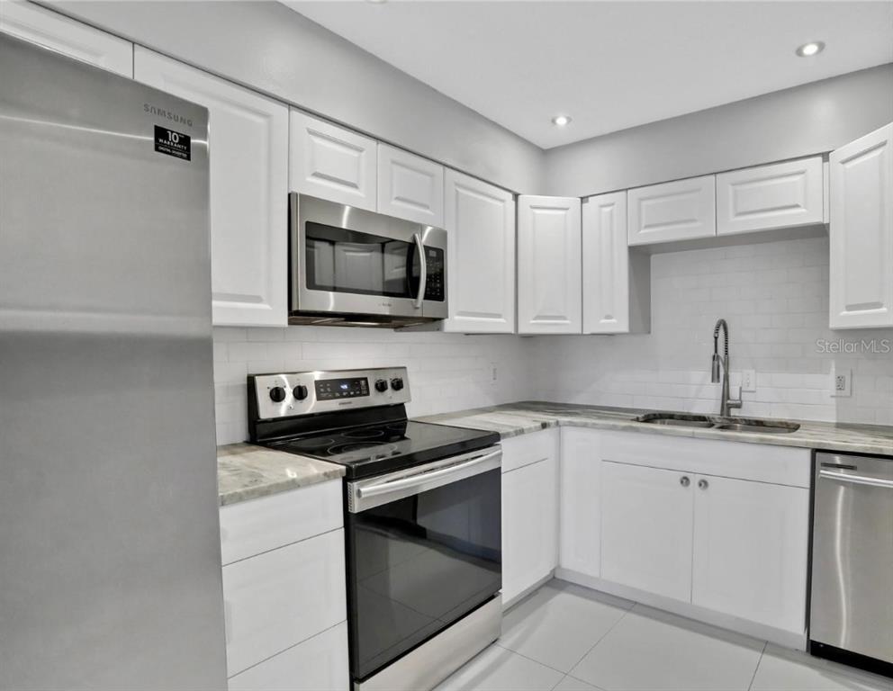 A kitchen with white cabinets, stainless steel appliances, and light-colored countertops — 540 ORANGE DRIVE UNIT 13, ALTAMONTE SPRINGS, FL