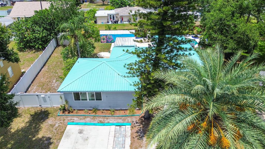 An aerial view shows a house with a bright turquoise metal roof and palm trees — 1509 CANTERBURY ROAD N, ST PETERSBURG, FL