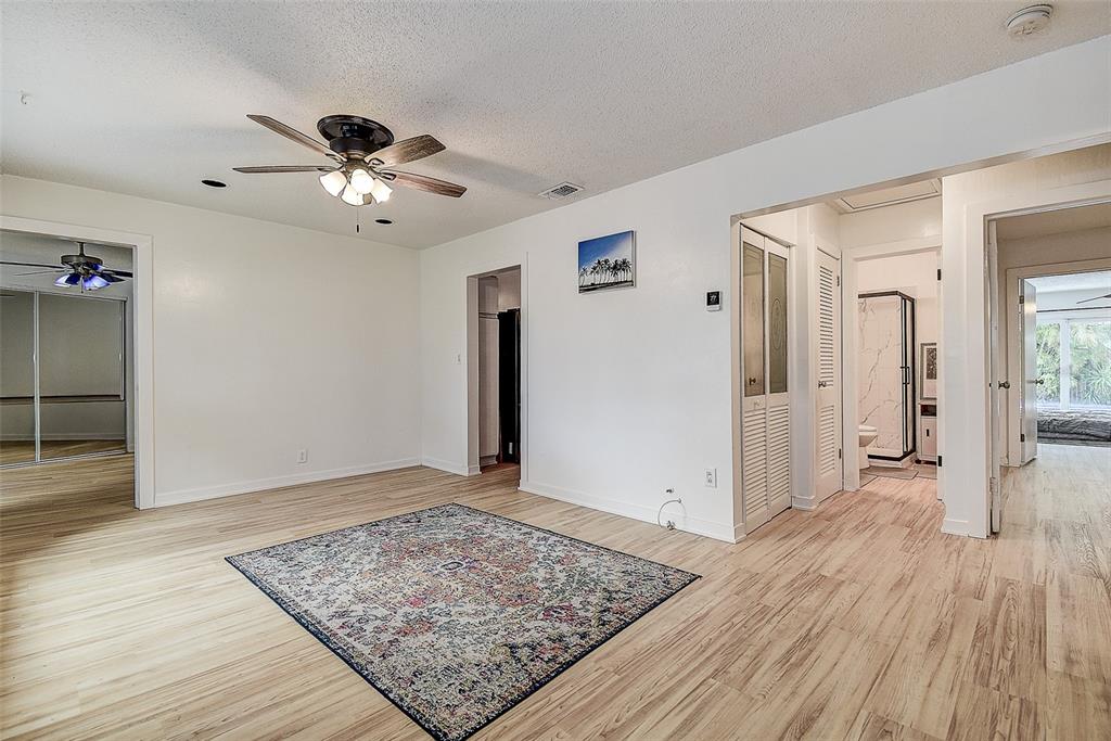 A room with light wood flooring, a ceiling fan, and a patterned area rug — 1509 CANTERBURY ROAD N, ST PETERSBURG, FL