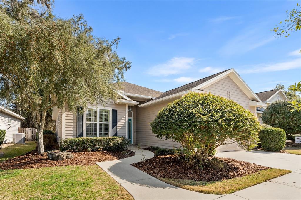 A single-story house with light-colored siding, a concrete walkway, and a landscaped front yard — 3737 SW 74TH DRIVE, GAINESVILLE, FL