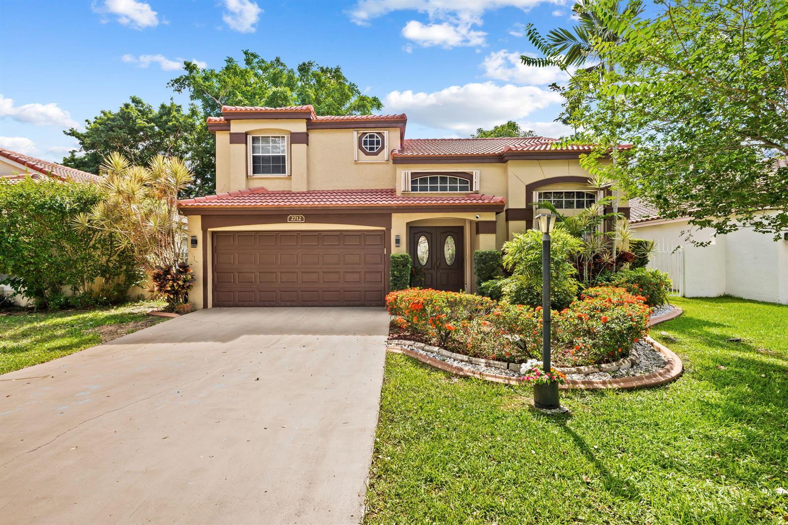 A two-story house with a brown garage door, tile roof, and landscaped front yard — 2712 Cayenne Avenue, Cooper City FL 33026, COOPER CITY, FL