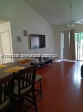 A dining area with a wooden table and chairs opens into a living room — 12142 Saint Andrews Pl # 306, Miramar FL 33025, MIRAMAR, FL