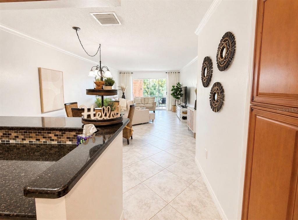 A view from a kitchen counter looking into a living room with tile flooring — 1624 STICKNEY POINT ROAD UNIT 206, SARASOTA, FL