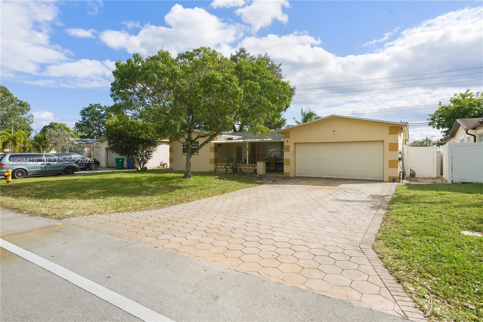 A single-story house with a paved driveway, a large tree, and a two-car garage — 7630 Embassy Blvd, Miramar FL 33023, MIRAMAR, FL