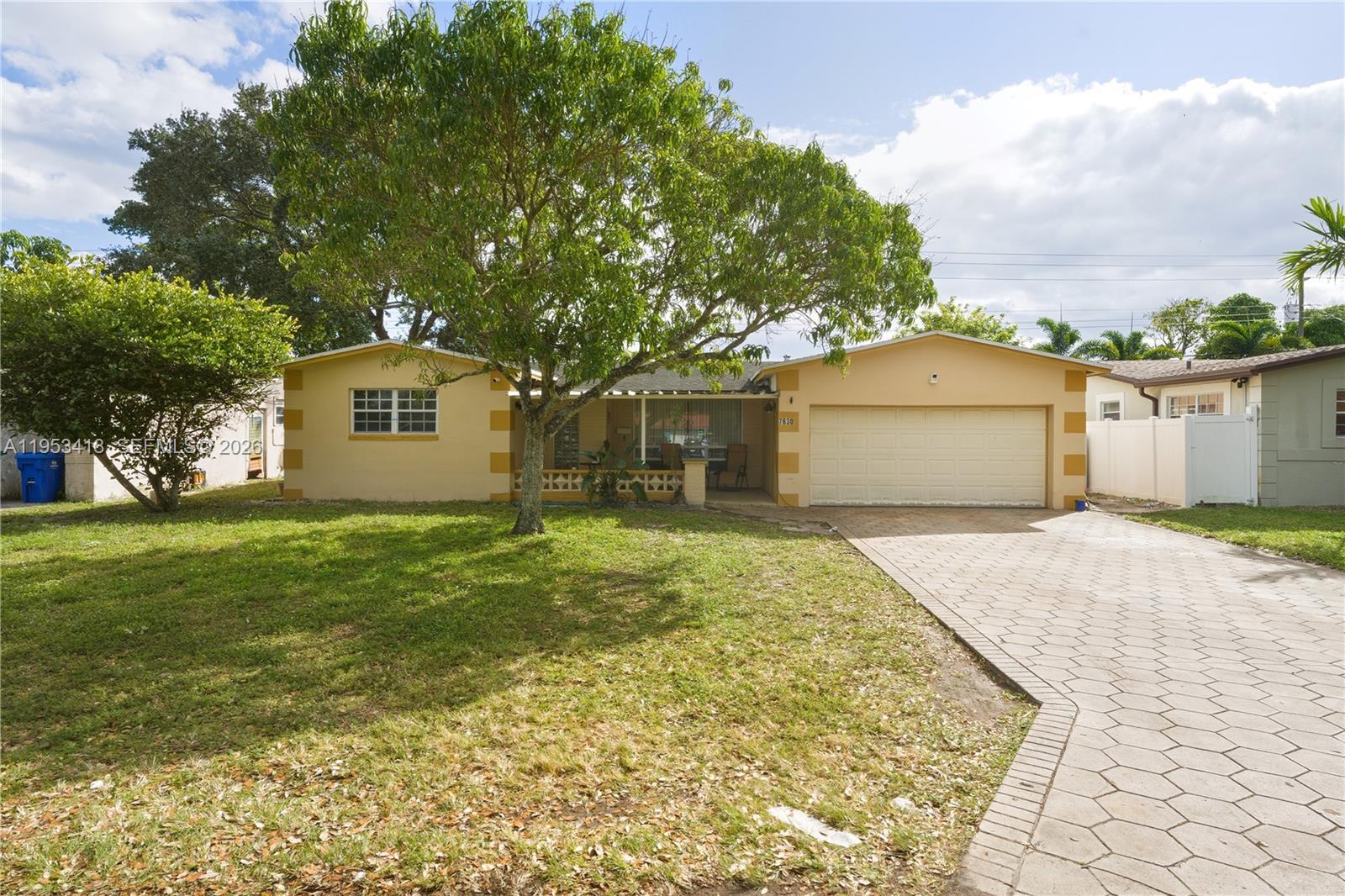 A single-story house with a yellow exterior, a paved driveway, and a large front tree — 7630 Embassy Blvd, Miramar FL 33023, MIRAMAR, FL