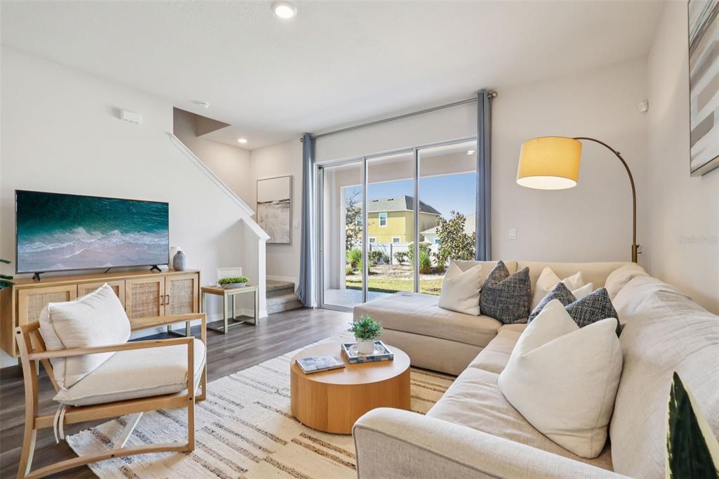 A living room features a sectional sofa, an armchair, a coffee table, and sliding glass doors — 2614 OLYMPIC COURT, DAVENPORT, FL