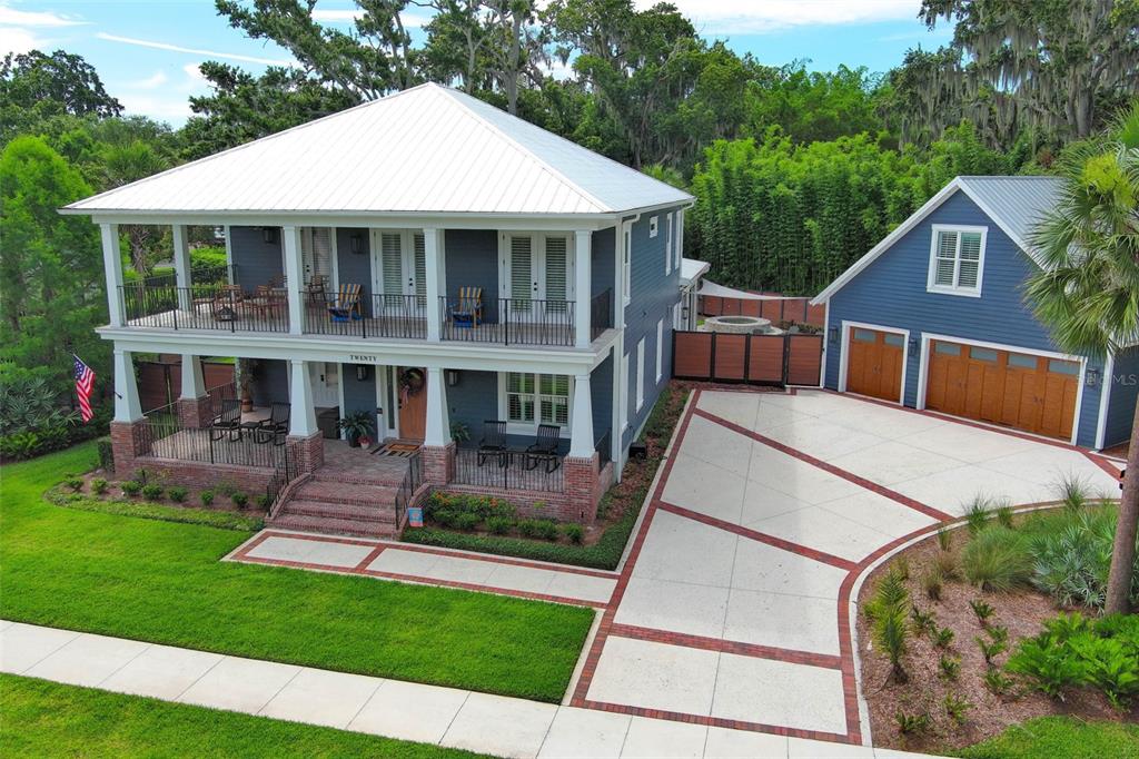 An elevated two-story blue house with a metal roof, front porches, and a detached garage — 20 W CREST AVENUE, WINTER GARDEN, FL