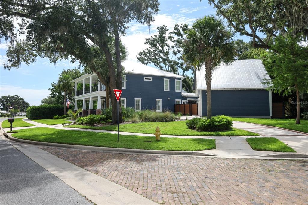 A blue two-story house with a metal roof and a wrap-around porch sits on a corner — 20 W CREST AVENUE, WINTER GARDEN, FL