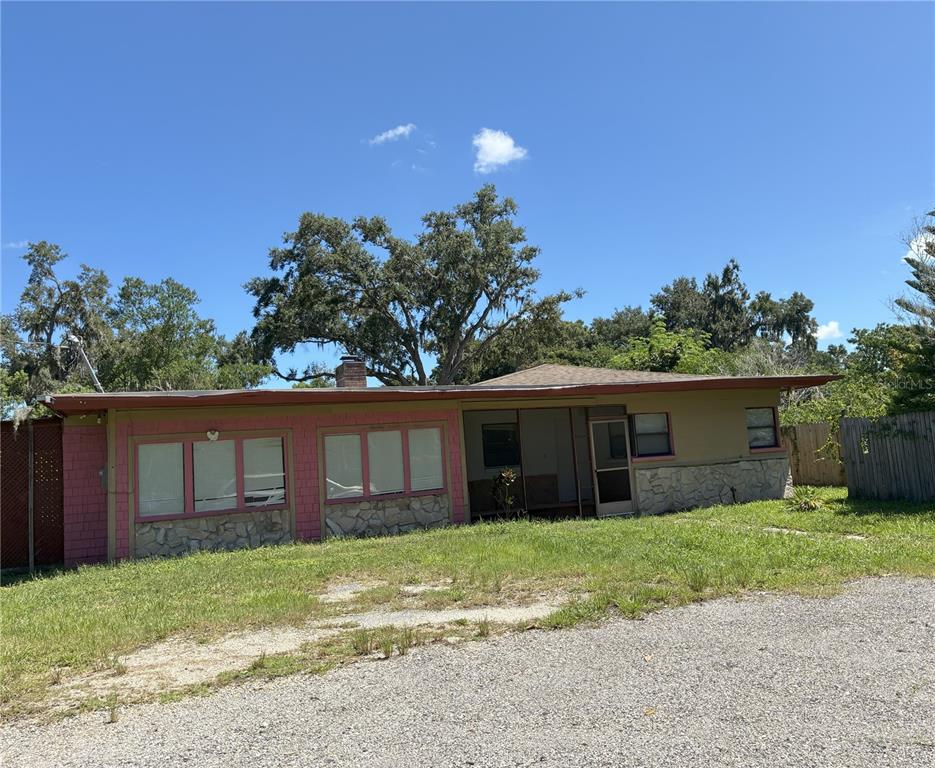 A single-story house with a stone-accented exterior, pink trim, and a gravel driveway — 3016 BLOOMINGDALE AVENUE, VALRICO, FL