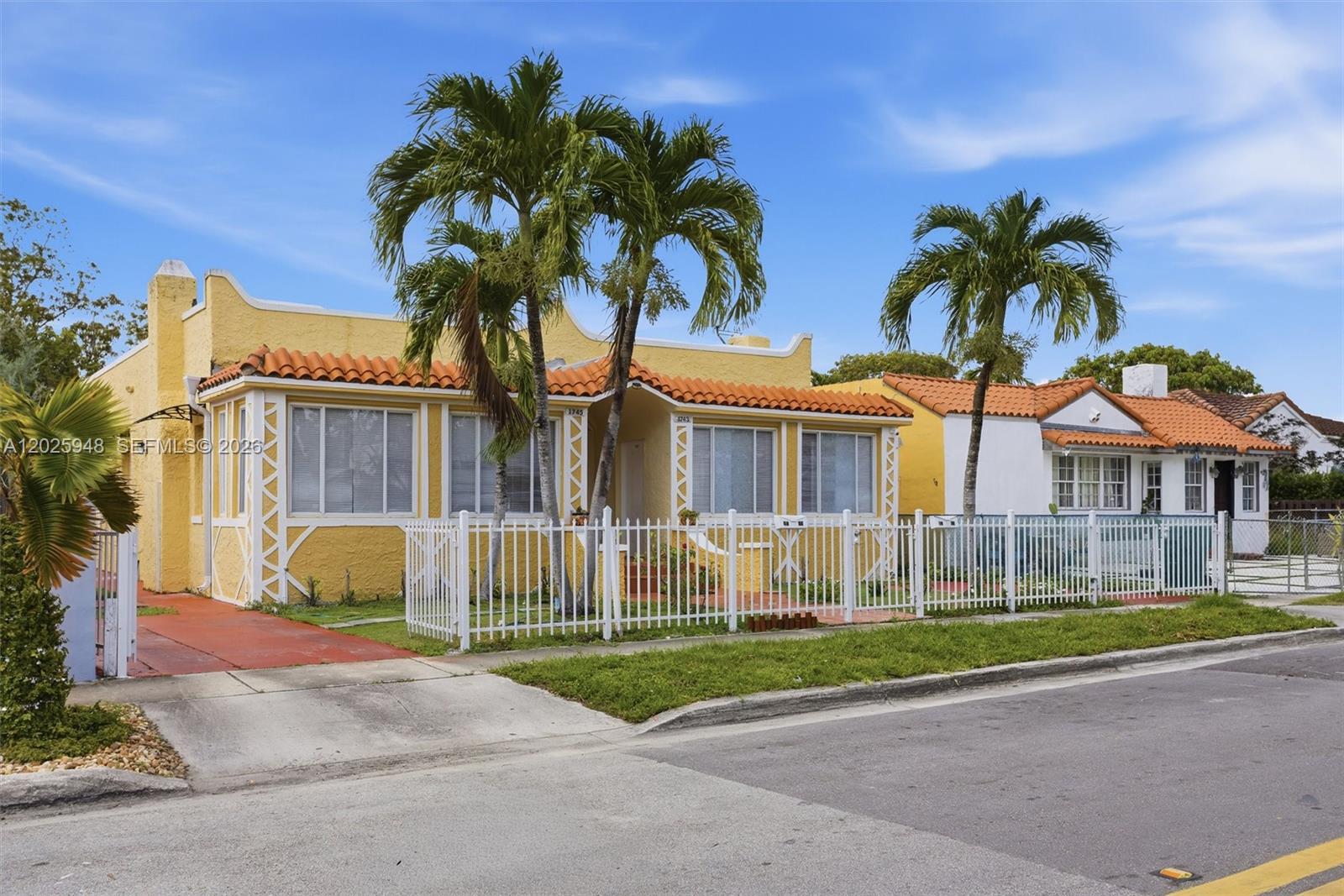 A yellow stucco house with a red tile roof stands behind a white picket fence — 1745 SW 17th St # 2, Miami FL 33145, MIAMI, FL
