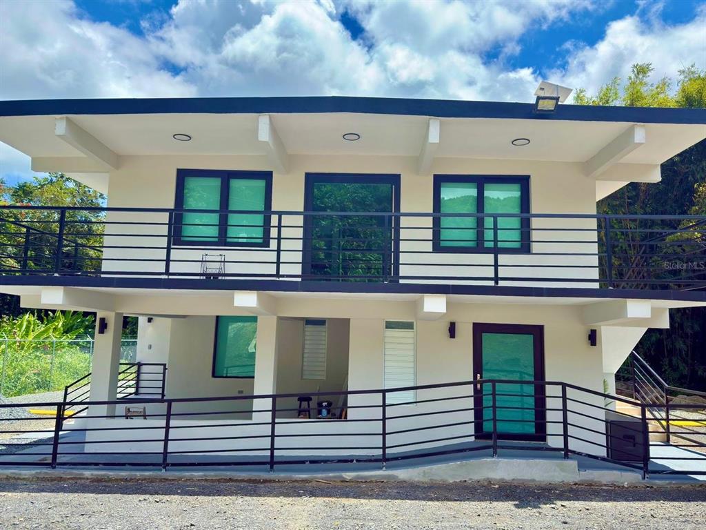 A two-story house with a balcony, metal railings, and a ramp leading to the entrance — Solar 2 BARRIO ZARZAL, RIO GRANDE, PR