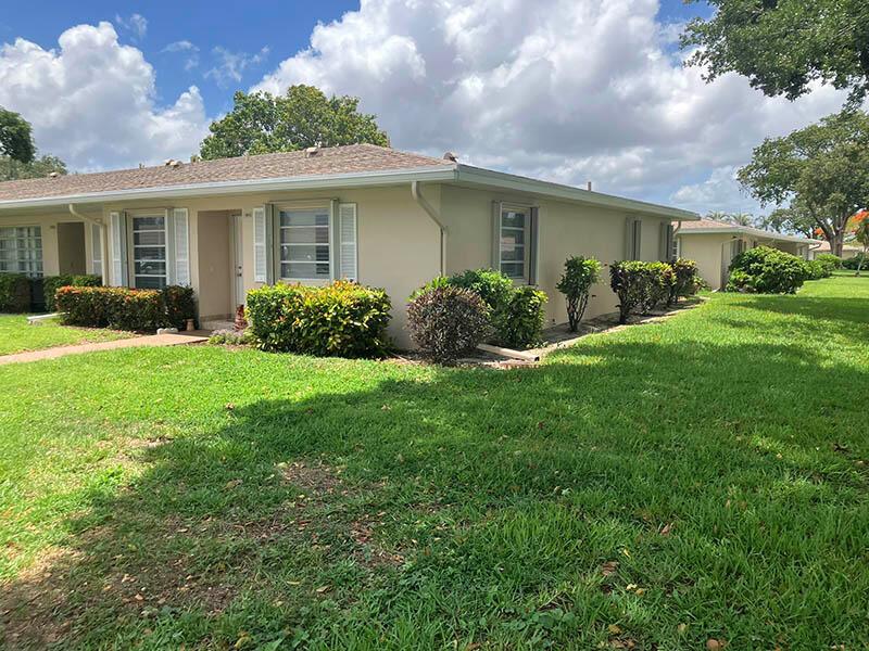 A single-story beige apartment building with a shingled roof and landscaped bushes in front — 8871 Warwick Drive, Boca Raton FL 33433, BOCA RATON, FL