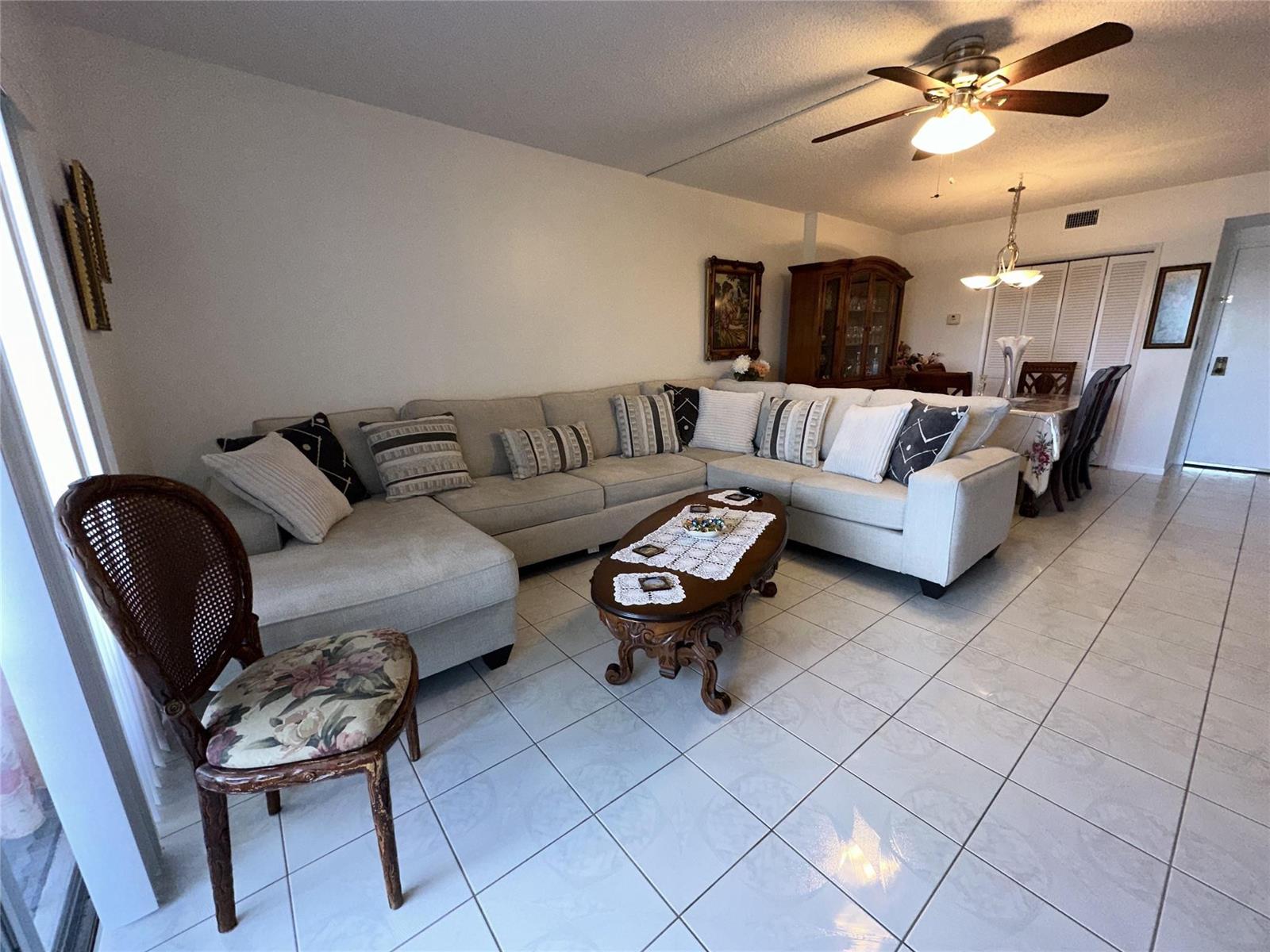 A living room with a large sectional sofa, a wooden coffee table, and tile flooring — 4330 Hillcrest Drive # 904, Hollywood FL 33021, HOLLYWOOD, FL