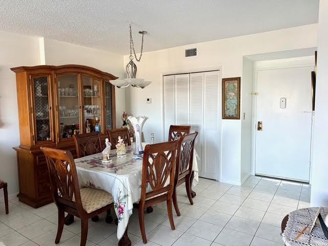 A dining room features a wooden hutch, a table with chairs, and white tile flooring — 4330 Hillcrest Drive # 904, Hollywood FL 33021, HOLLYWOOD, FL