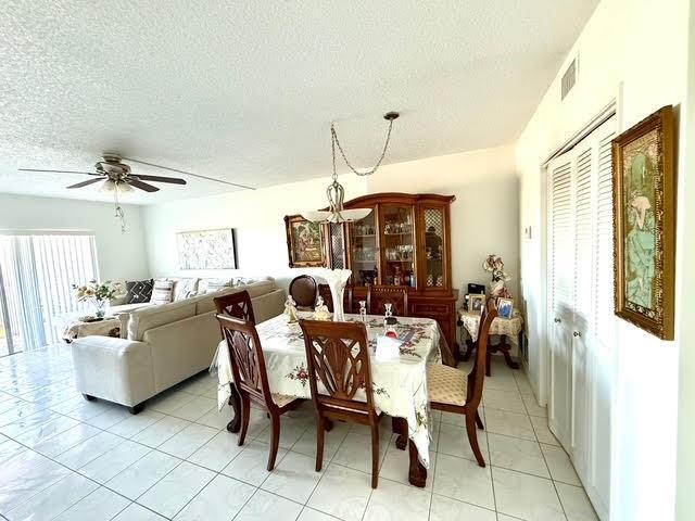 A dining area with a wooden table and hutch sits beside a living room — 4330 Hillcrest Drive # 904, Hollywood FL 33021, HOLLYWOOD, FL