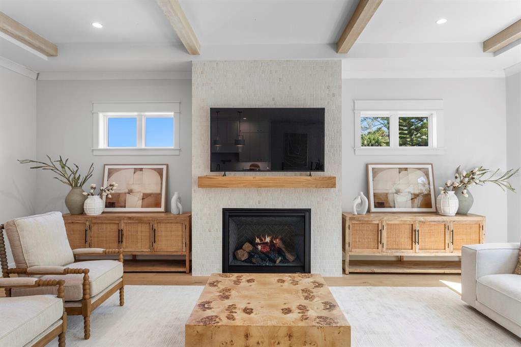 A living room features a tiled fireplace, wood mantel, television, and symmetrical wooden cabinets — 2312 S OCCIDENT STREET, TAMPA, FL