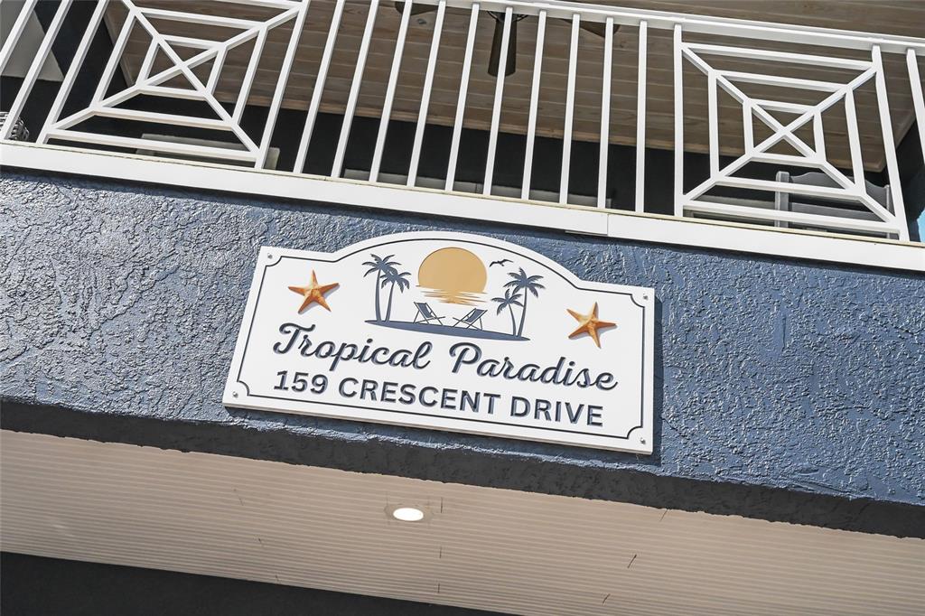 A sign reading Tropical Paradise is mounted on the blue stucco exterior of a building — 159 CRESCENT DRIVE, ANNA MARIA, FL