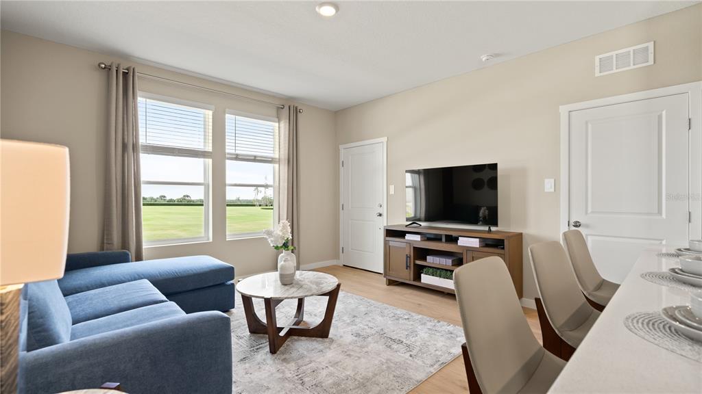 A living room features a blue sectional sofa, a marble coffee table, and a television console — 5247 HAVEN VIEW DRIVE, CLERMONT, FL