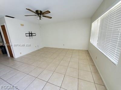 An empty room features light-colored tile flooring, a ceiling fan, and a large window — 4619 SW 7TH PL, Cape Coral FL 33914, CAPE CORAL, FL