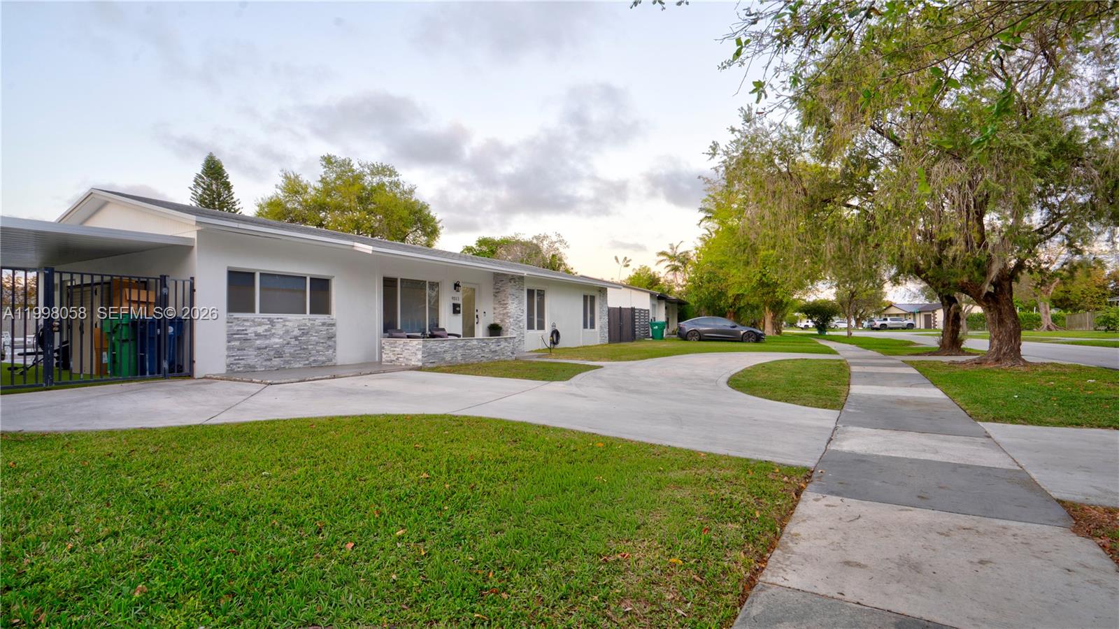 A single-story house features a concrete driveway, a carport, and a stone-accented exterior wall — 9311 Sterling Dr, Cutler Bay FL 33157, CUTLER BAY, FL