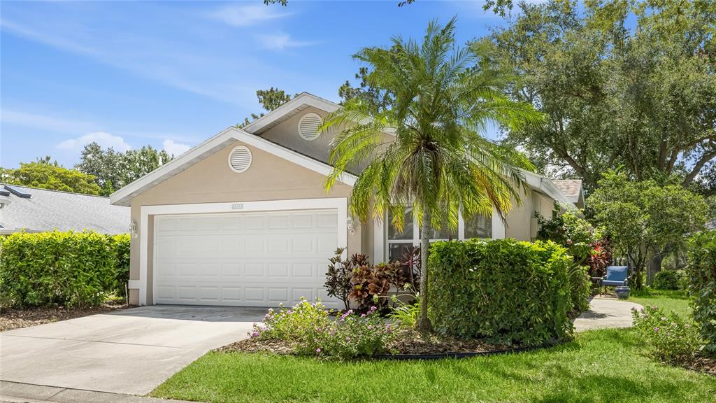 A single-story house with a beige exterior, a two-car garage, and a palm tree — 7317 ELEANOR CIRCLE UNIT 176, SARASOTA, FL
