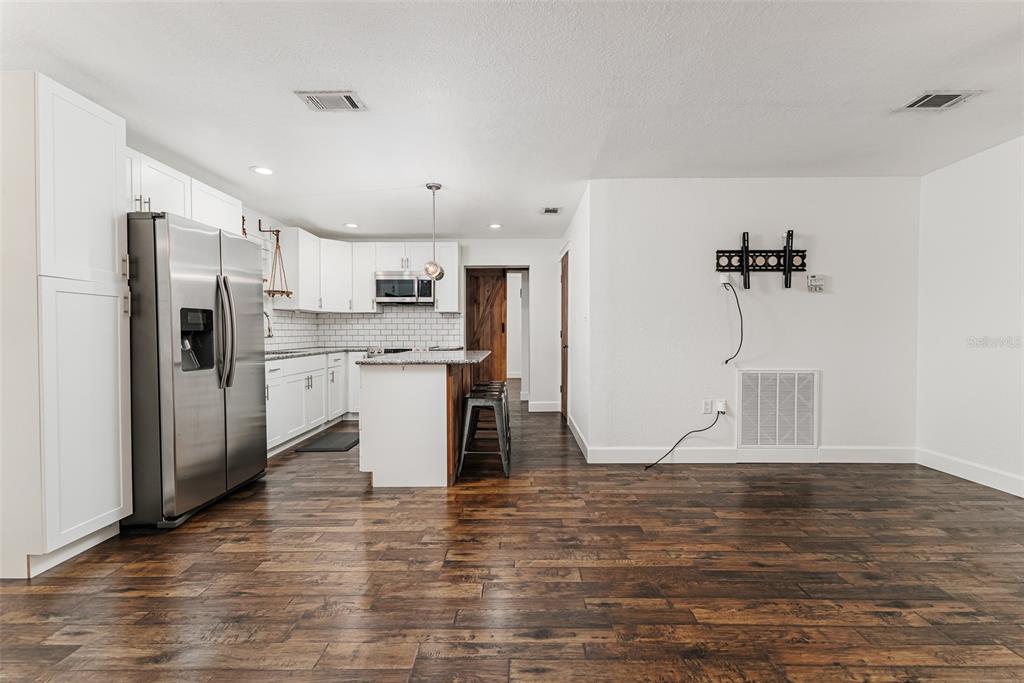 A kitchen with white cabinets, stainless steel appliances, and a wood-topped island with bar stools — 2220 MINI RANCH ROAD, LAKELAND, FL