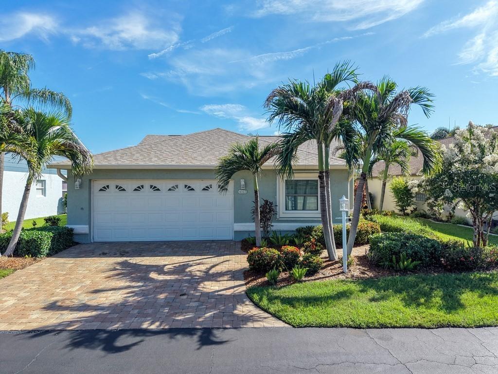 A single-story house with a paved driveway, palm trees, and a two-car garage — 4322 EDENROSE WAY UNIT 86, SARASOTA, FL