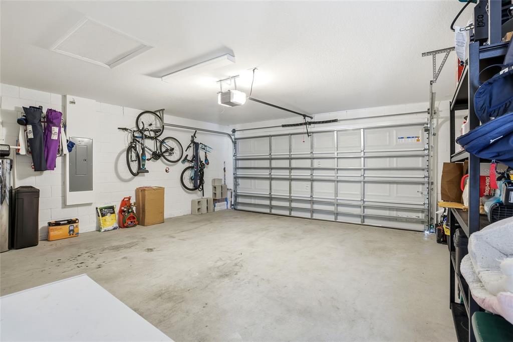 A garage with a concrete floor, white block walls, and two bicycles mounted on the wall — 3536 YARIAN DRIVE, HAINES CITY, FL