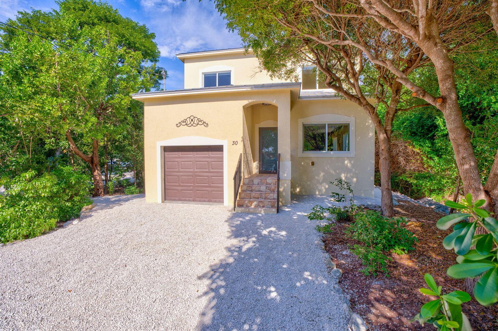An aerial view of a two-story house with a metal roof and attached garage — 30 Seagate Boulevard, Key Largo FL 33037, KEY LARGO, FL