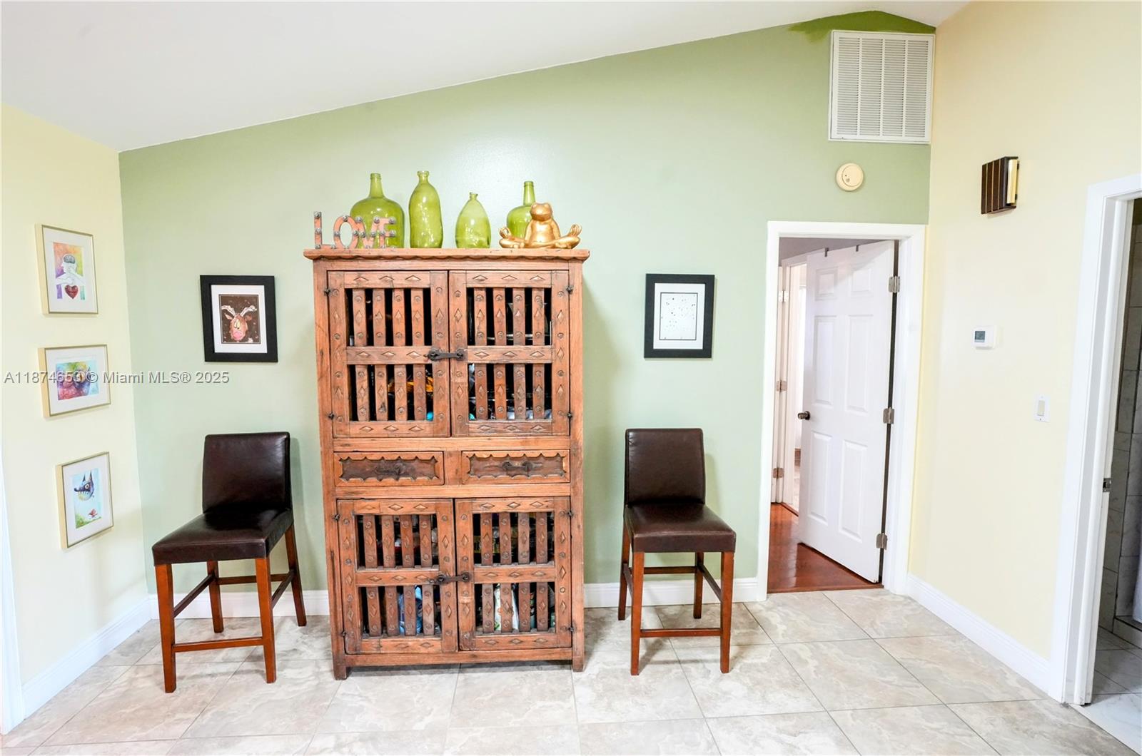 A room features a wooden cabinet flanked by two chairs against a green wall — 2304 SE 8TH TER, Cape Coral FL 33990, CAPE CORAL, FL