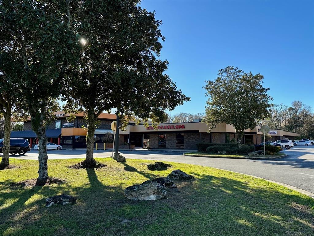 A commercial strip mall building with a restaurant and a nail spa under a clear sky — 3501 SW 2ND AVENUE UNIT 2400, GAINESVILLE, FL