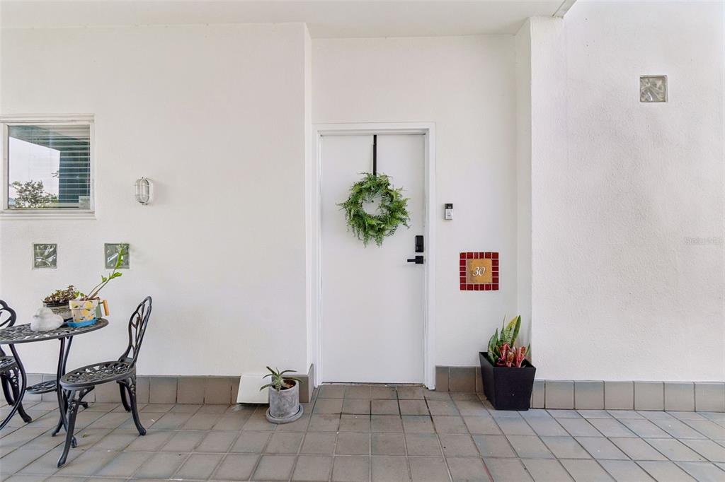 A white front door with a wreath and house number 30 sits on a tiled patio — 4950 BAYSHORE BOULEVARD UNIT 30, TAMPA, FL