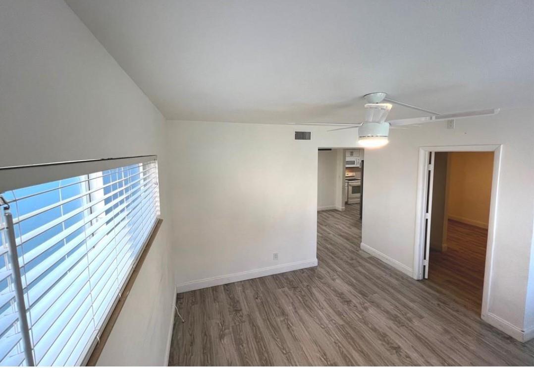 An empty room with light wood-look flooring, a ceiling fan, and a window with blinds — 1060 Crystal Lake Drive # 101, Deerfield Beach FL 33064, DEERFIELD BEACH, FL