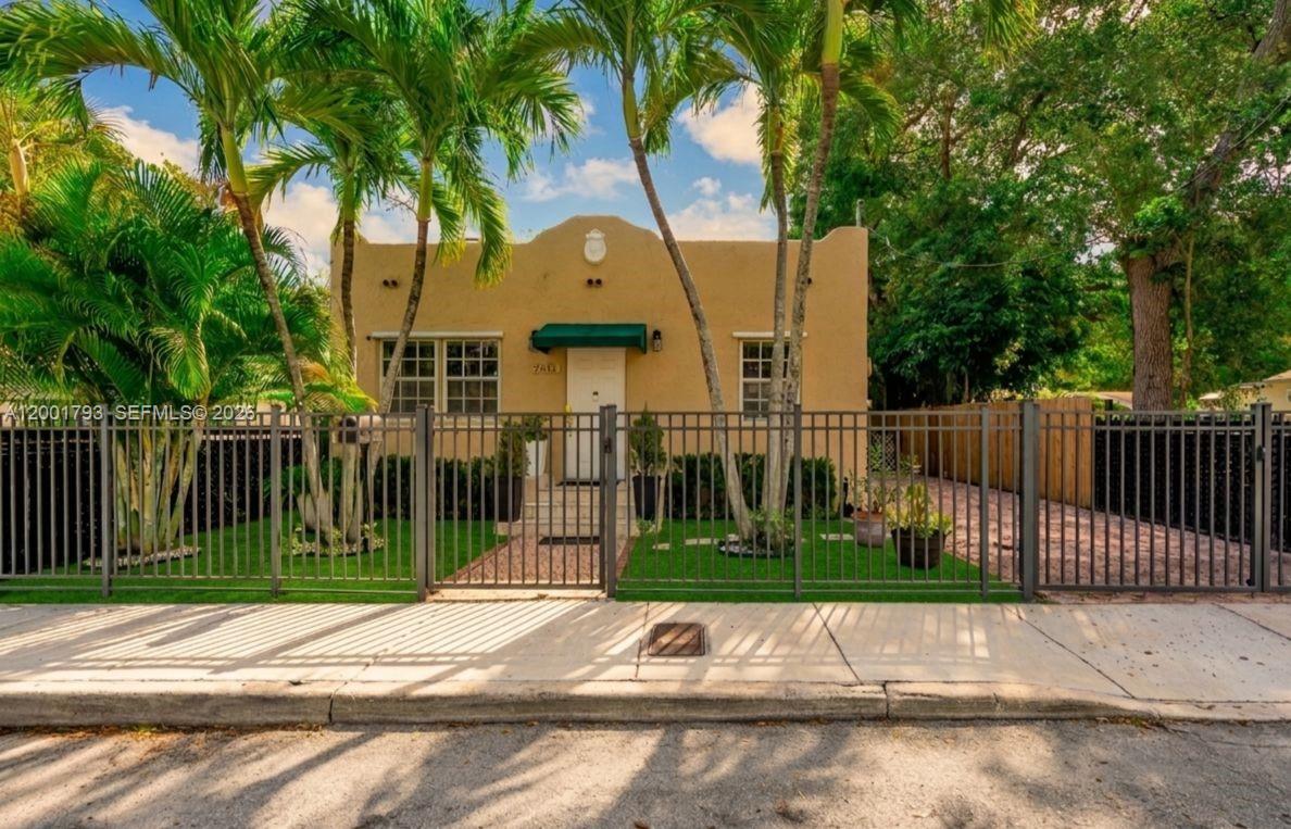 A single-story stucco house with a green awning stands behind a black metal fence — 7611 NW 3rd Ave, Miami FL 33150, MIAMI, FL