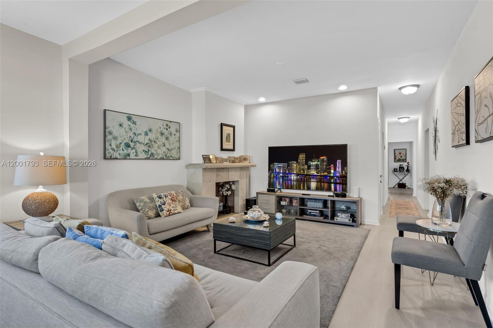 A living room features a fireplace, a television on a console, and gray seating — 7611 NW 3rd Ave, Miami FL 33150, MIAMI, FL