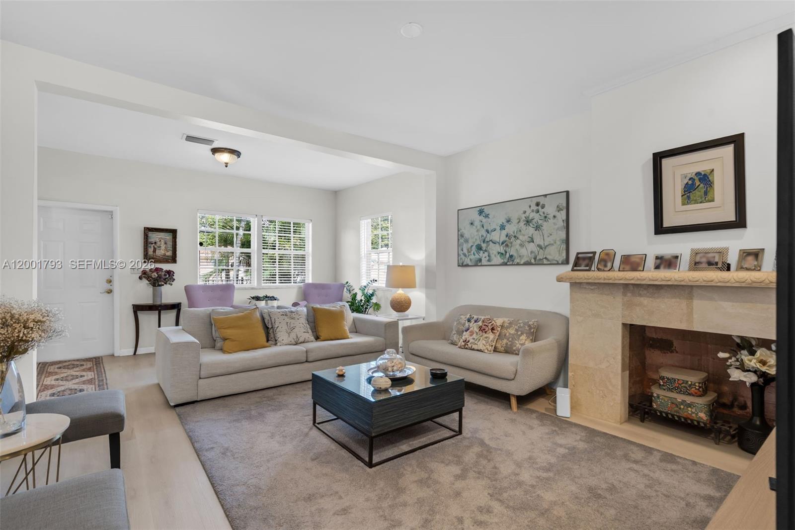 A living room features a stone fireplace, light-colored sofas, and a central coffee table — 7611 NW 3rd Ave, Miami FL 33150, MIAMI, FL
