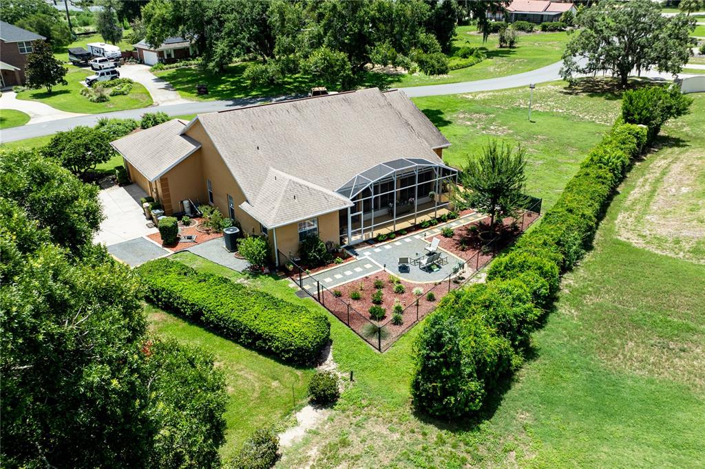An aerial view shows a single-story house with a tan exterior and a large driveway — 34021 PARK LANE, LEESBURG, FL